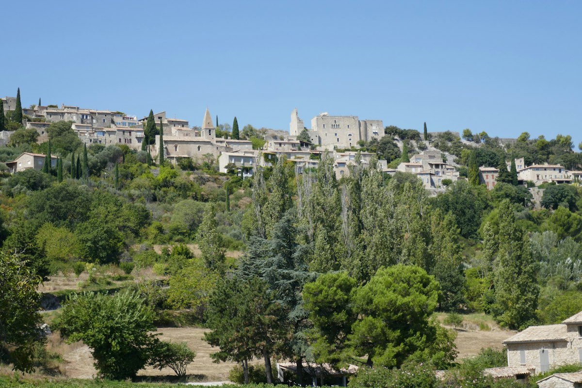 Village au sommet d’une colline entourée d’arbres Village au sommet d’une colline entourée d’arbres